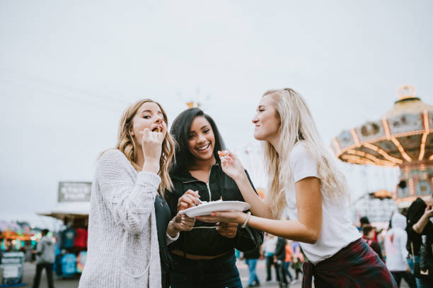 teenage women friend group enjoying state fair - food stock pictures, royalty-free photos & images