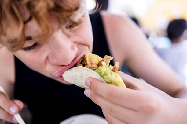 teenager boy is eating a chicken taco - junk food stock pictures, royalty-free photos & images