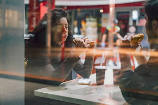 teenagers friends sitting at the fast food together - junk food stock pictures, royalty-free photos & images