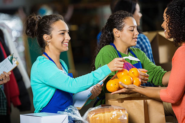 teenagers passing out donations at food bank donation drive - food stock pictures, royalty-free photos & images