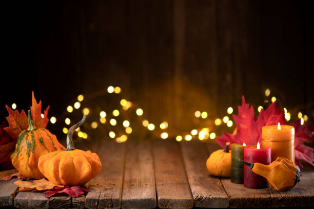 thanksgiving decoration with pumpkins and greeting card on illuminated background and a rustic wooden table - home decoration stock pictures, royalty-free photos & images