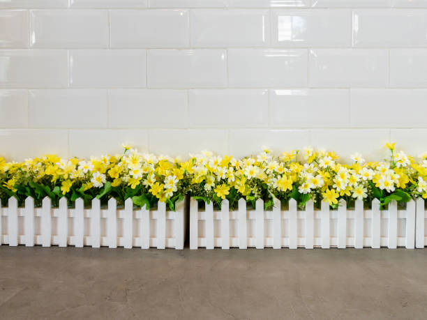 the artificial flower row in the white fence - garden decoration stock pictures, royalty-free photos & images