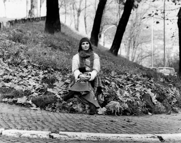 The Italian film, theatre and television actress Paola Pitagora is seated with crossed legs on a garden covered with fallen leaves; the actress, who...