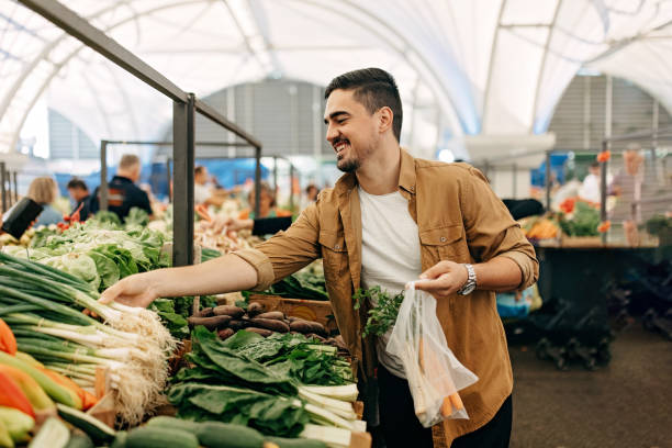 the man behind the vegetable stand. - food stock pictures, royalty-free photos & images