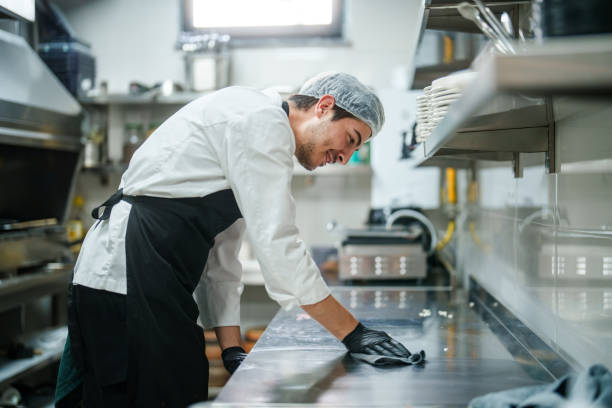 the restaurant chef is wiping down the kitchen counter. - food stock pictures, royalty-free photos & images