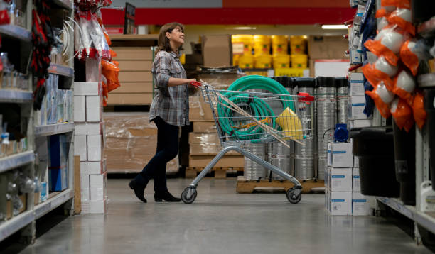 thoughtful woman buying materials at a hardware store - home decoration stock pictures, royalty-free photos & images