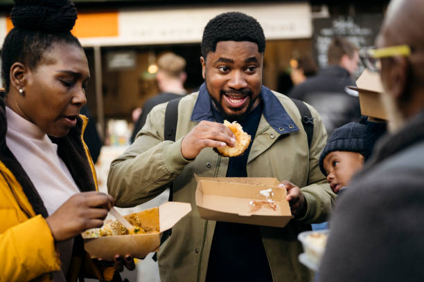 three-generation family eating at london market hall - junk food stock pictures, royalty-free photos & images