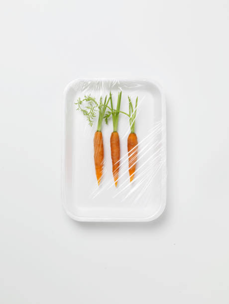 three baby carrots encased in plastic wrapping - food stock pictures, royalty-free photos & images