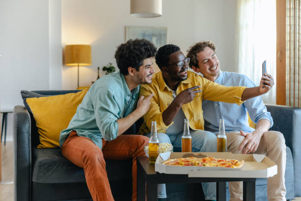 three friends having fun taking a selfie during a casual gathering at home - junk food stock pictures, royalty-free photos & images