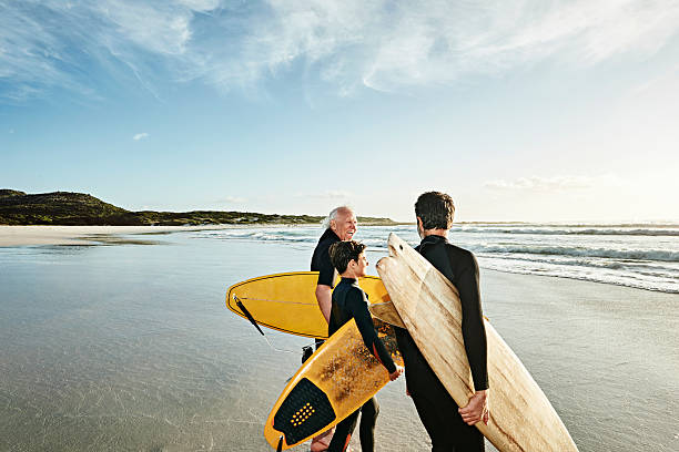 three generations of surfers on beach - travel stock pictures, royalty-free photos & images