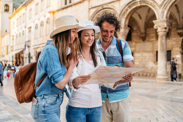 three young friends reading a map on the street in dubrovnik - travel stock pictures, royalty-free photos & images