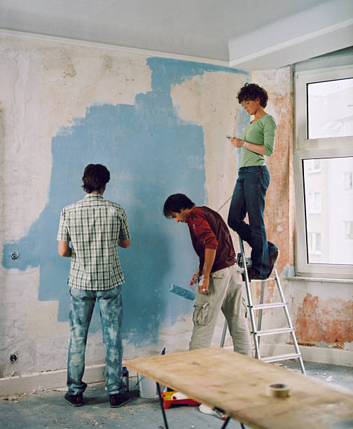 three young people renovating a room - home decoration stock pictures, royalty-free photos & images