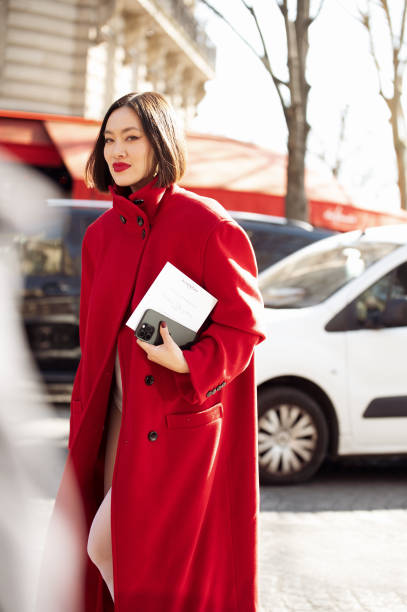 Tiffany Hsu wears white tights, white micro shorts, red coat outside Givenchy fashion show during the Womenswear Fall/Winter 2025/2026 as part of...