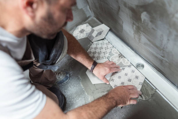 tiler installing tiles on the bathroom floor - home decoration stock pictures, royalty-free photos & images