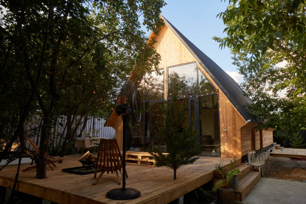 timber frame house with garlands building exterior view through trees - garden decoration stock pictures, royalty-free photos & images