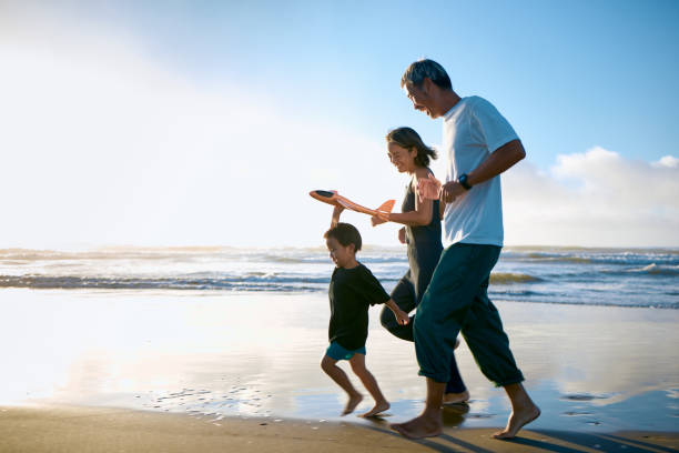 toddler running on beach with toy airplane - travel stock pictures, royalty-free photos & images