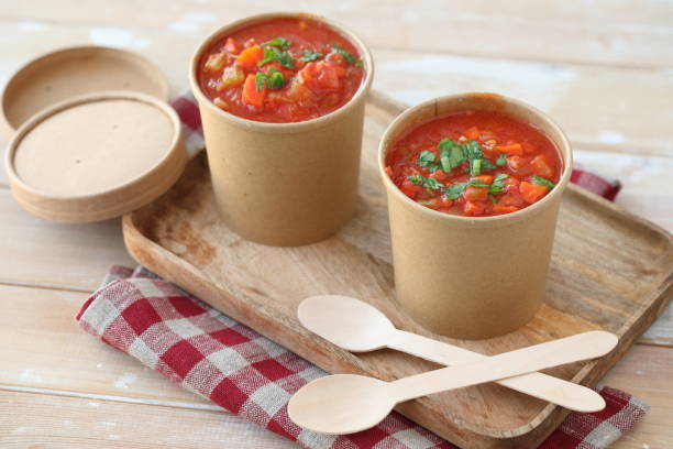 tomato soup in disposable paper cups on a wooden tray with wooden spoons - junk food stock pictures, royalty-free photos & images