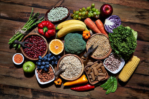 top view of dietary fiber fresh vegan food and legumes on rustic wooden table. healthy food themes with frame and copy space. - food stock pictures, royalty-free photos & images