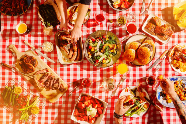 top view of fast food, hands and people at picnic, lunch meal or snack with barbecue, casual cuisine for nutrition and health. diner, cooking and culinary experience with buffet or summer restaurant - junk food stock pictures