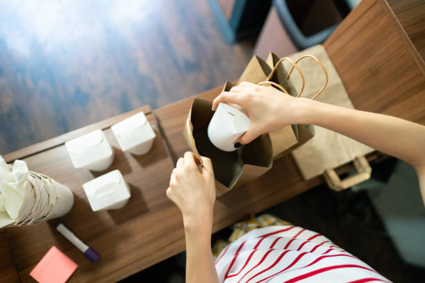 top view of fast food worker packing food for delivery - junk food stock pictures, royalty-free photos & images