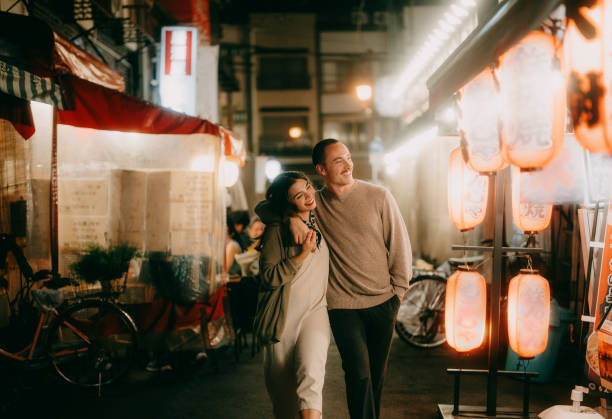 tourist couple enjoying backstreet alley in tokyo at night - travel stock pictures, royalty-free photos & images