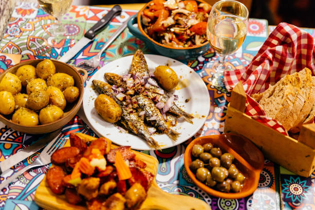 traditional portuguese dinner with grilled sardines, potatoes, olives, octopus salad and fresh bread, lisbon, portugal - food stock pictures, royalty-free photos & images
