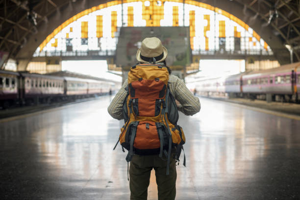 traveler man waits train on railway platform. - travel stock pictures, royalty-free photos & images