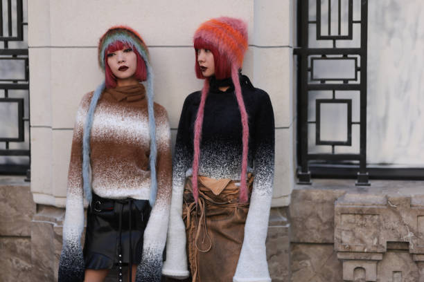 Twins Ami & Aya Amiaya were seen wearing a black and brown skirt, colorful hats and white and brown as well as white and black striped pullover with...
