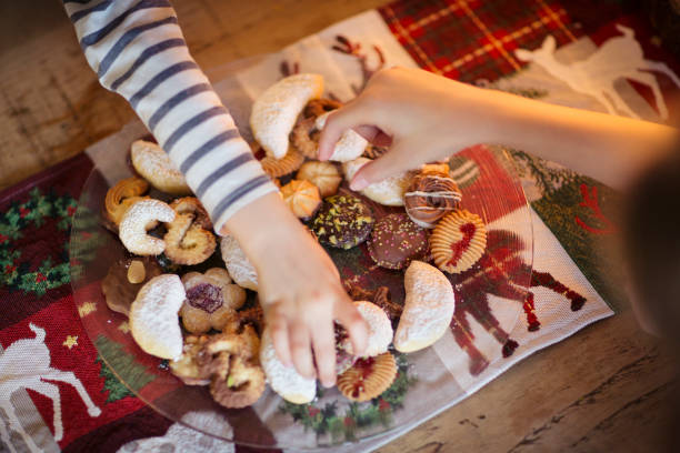 two children choosing traditional german christmas cookies - junk food stock pictures, royalty-free photos & images