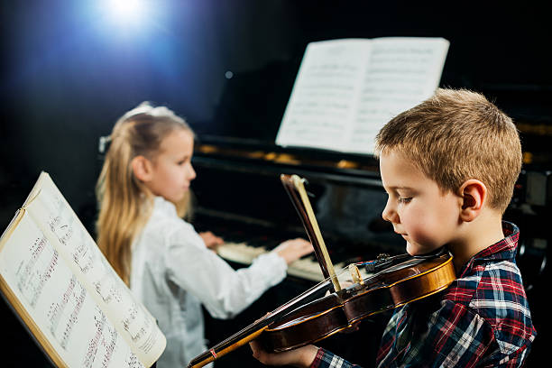 two children playing musical instruments. - concert stock pictures, royalty-free photos & images