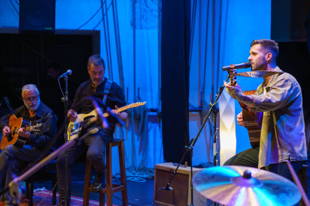 two guitarists and singer playing on stage - concert stock pictures, royalty-free photos & images
