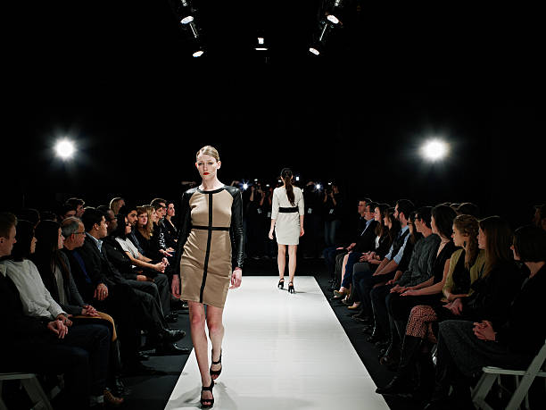 two models walking on catwalk during fashion show - fashion week stock pictures, royalty-free photos & images