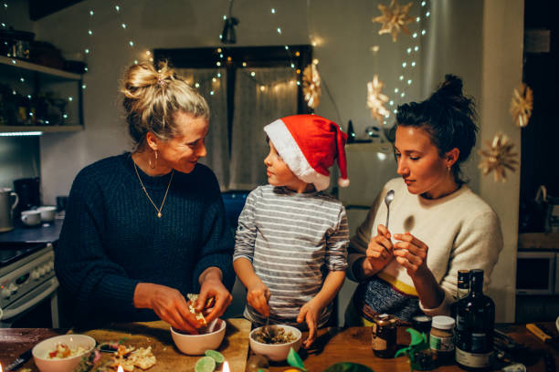 two women preparing christmas dinner with young boy - food stock pictures, royalty-free photos & images