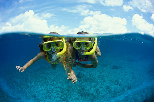 two young girls snorkeling (cayman) - travel stock pictures, royalty-free photos & images