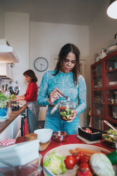 two young woman preparing fresh food for take away - junk food stock pictures, royalty-free photos & images