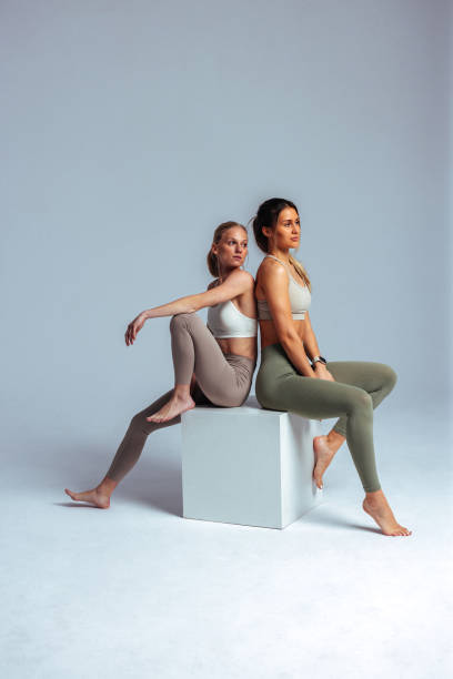 two young women relaxing after fitness training session - fashion stock pictures, royalty-free photos & images