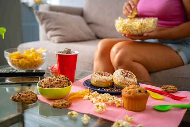 unhealthy eating concept. unrecognizable woman unhealthy eating - junk food stock pictures, royalty-free photos & images
