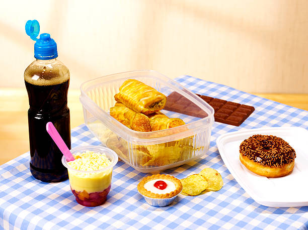 unhealthy lunch box on table cloth - junk food stock pictures, royalty-free photos & images