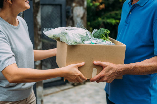 unkenntliche frau verteilt lebensmittelspenden während charity-fahrt - food stock-fotos und bilder