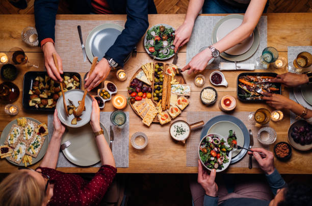 unrecognizable friends and family sharing food at dinning room - food stock pictures, royalty-free photos & images