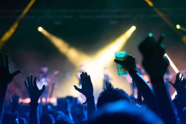 unrecognizable people with their hands up at a music concert. - concert stock pictures, royalty-free photos & images
