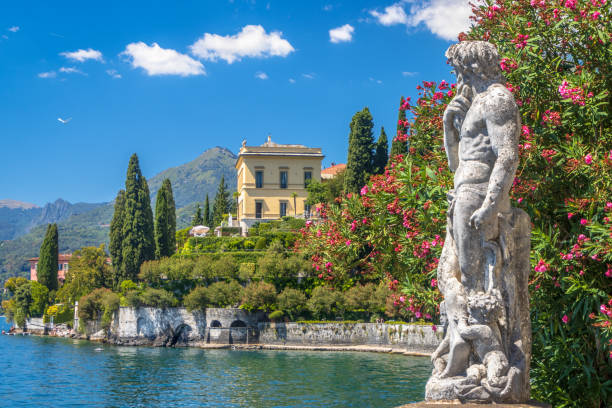 varenna, lombardy, italy - july 2022: statue in villa monastero overlooking lake como - garden decoration stockfoto's en -beelden