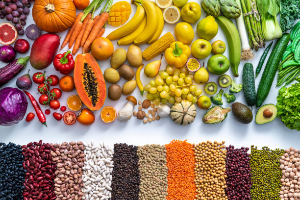 vegan food colorful fresh vegetables and fruits and dried legumes in a row on white - food stock pictures, royalty-free photos & images
