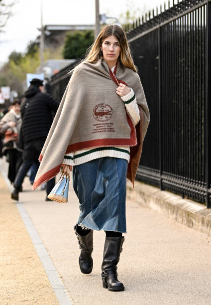 Veronika Heilbrunner is seen wearing a Lacoste blanket, cream and black sweater, blue jeans and black boots with tan and light blue bag outside the...