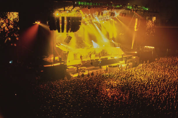 View of the audience as British band Oasis performs on stage, circa 1980.