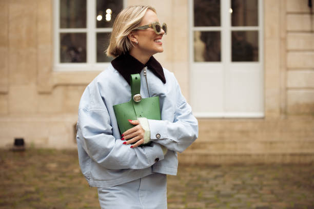 Violet Grace Atkinson wears light blue skirt, light blue jacket with black collar, green Loewe bag outside the LOEWE presentation during the...
