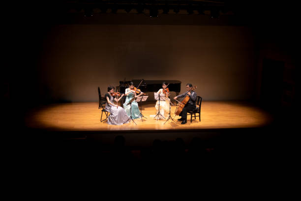 violinists and cellist playing at classical music concert - concert stock pictures, royalty-free photos & images