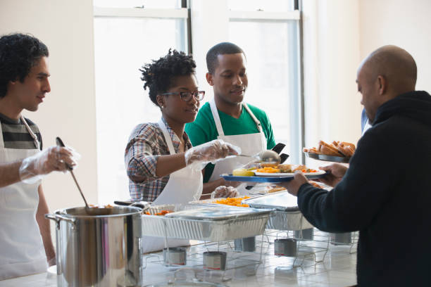 volunteers serving food in cafeteria - food stock pictures, royalty-free photos & images