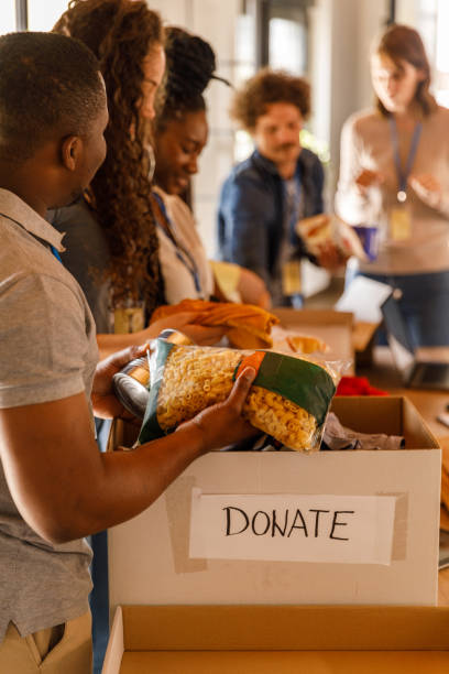 volunteers working together to organize boxes with donations - food stock pictures, royalty-free photos & images