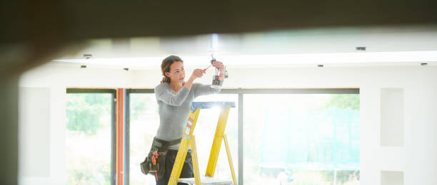 vrouwelijke elektricien installeren downlighters - home decoration stockfoto's en -beelden